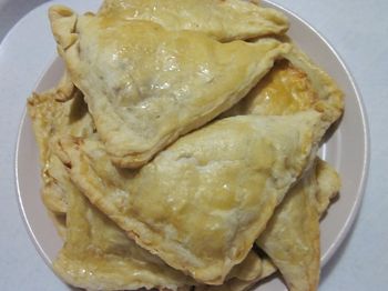 вкусные пирожки из слоеного теста с мясом на тарелке